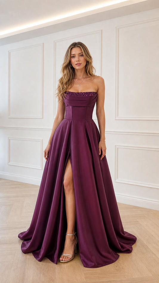 Model wearing plum satin strapless evening gown with front slit