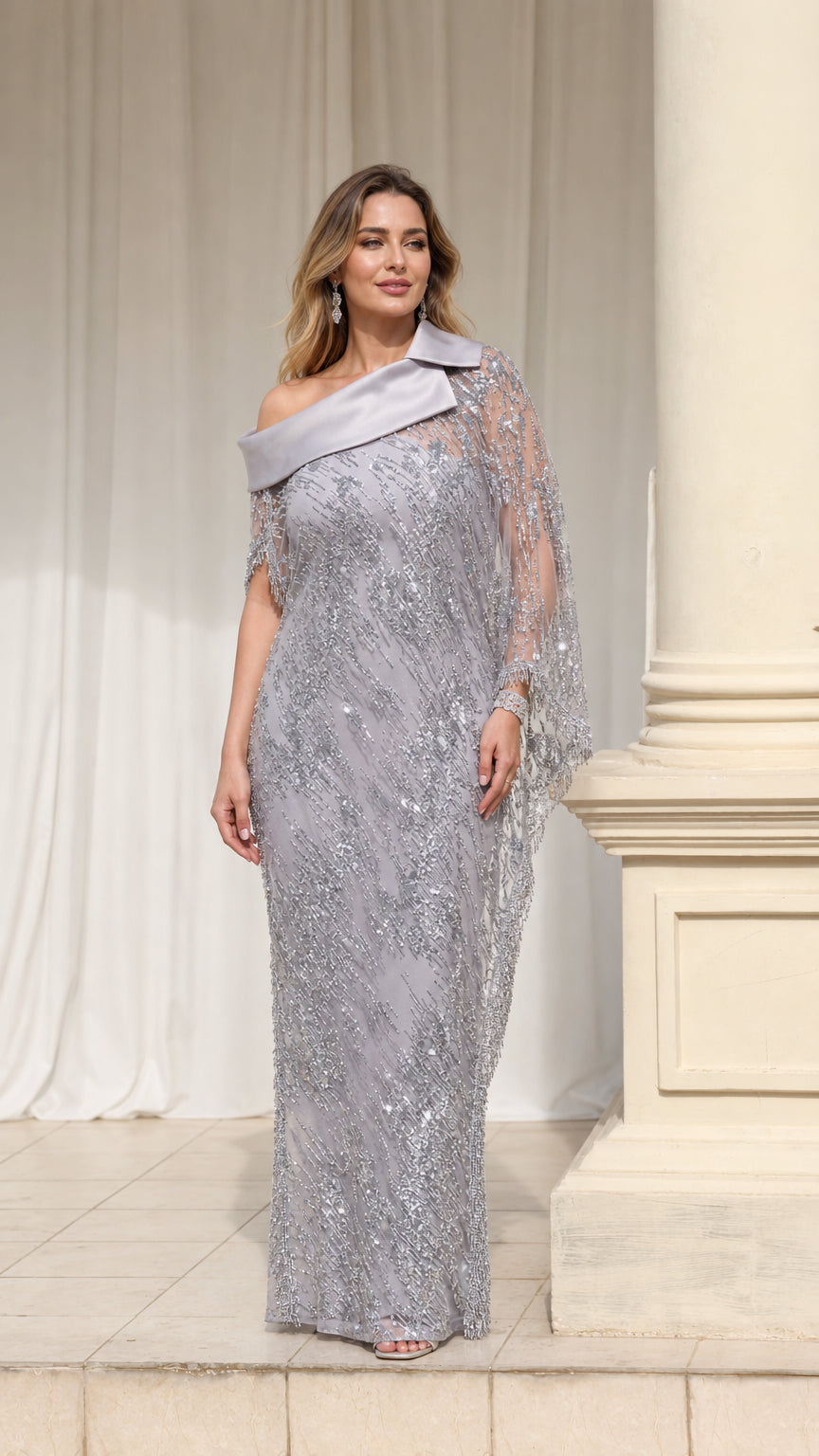 Front view of woman wearing silver sequin evening gown with asymmetrical satin lapel and capelet sleeves