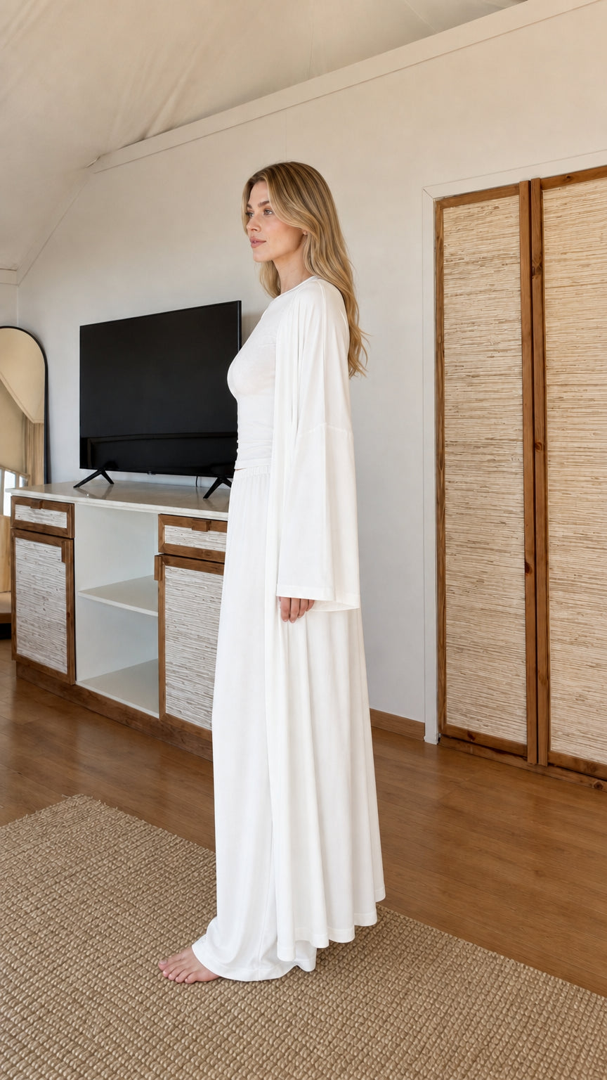 Side angle view of model wearing White 3-piece fluid lounge ensemble