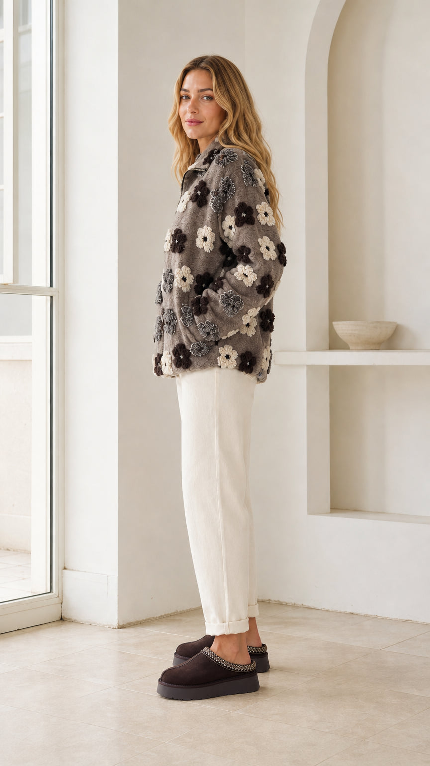 Side profile view of model wearing charcoal grey textured floral fleece jacket