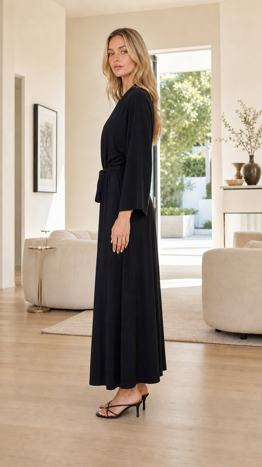 Side profile view of woman wearing Black maxi robe with tie belt