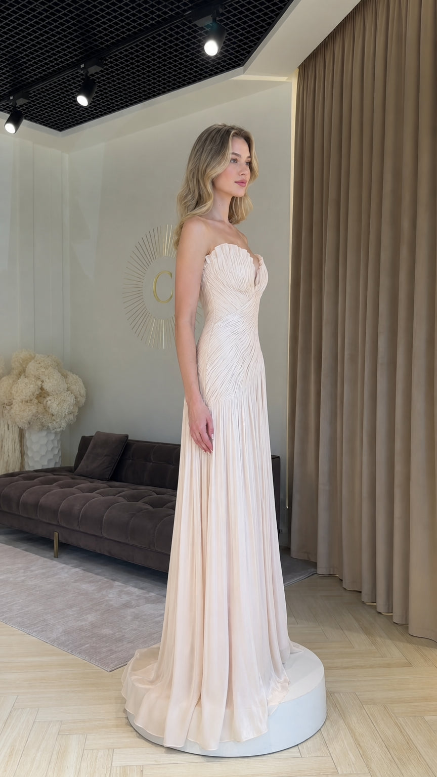 Side profile view of champagne evening gown showing structured bodice and flow