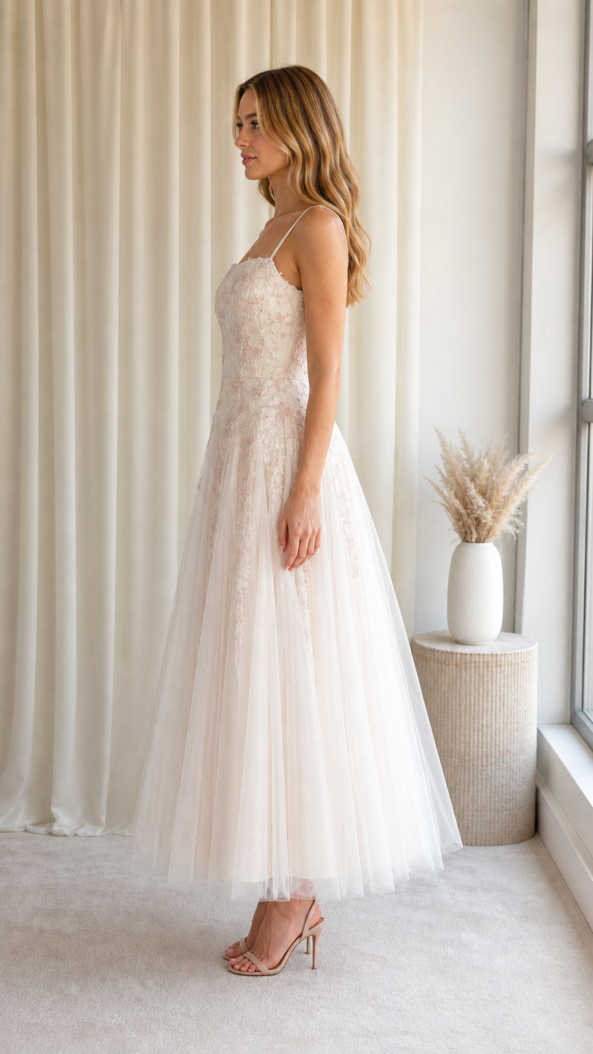 Side angle of model in Blush Ivory tea-length embroidered tulle formal dress