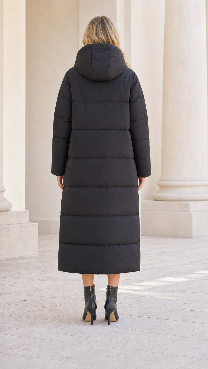 Back view of model wearing full-length black quilted winter puffer coat