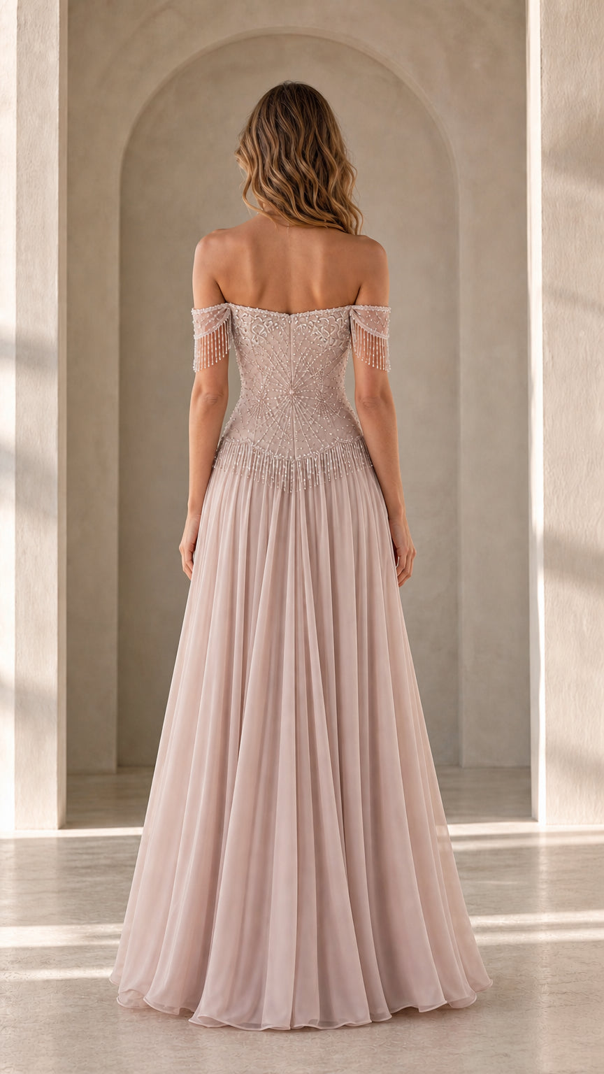 Back view of model in blush pink evening dress with pleated chiffon skirt