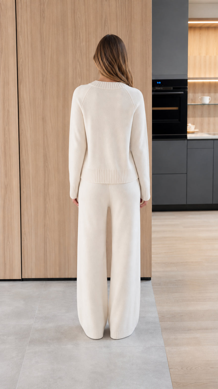 Back view of women's white knit cardigan and wide-leg trousers set
