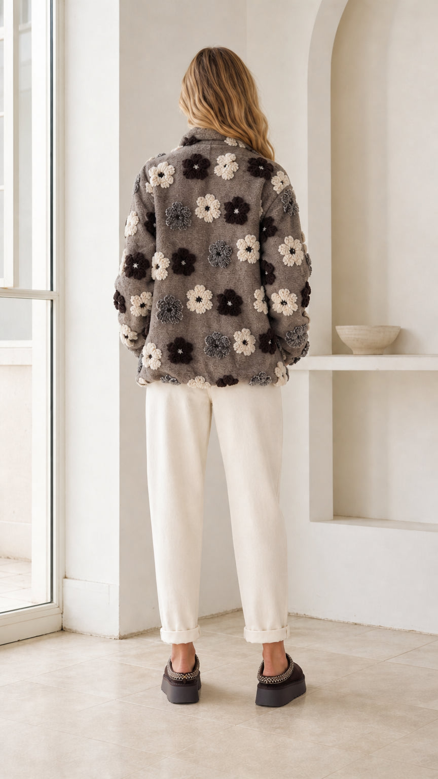 Back view of model wearing charcoal grey floral fleece jacket with stand collar