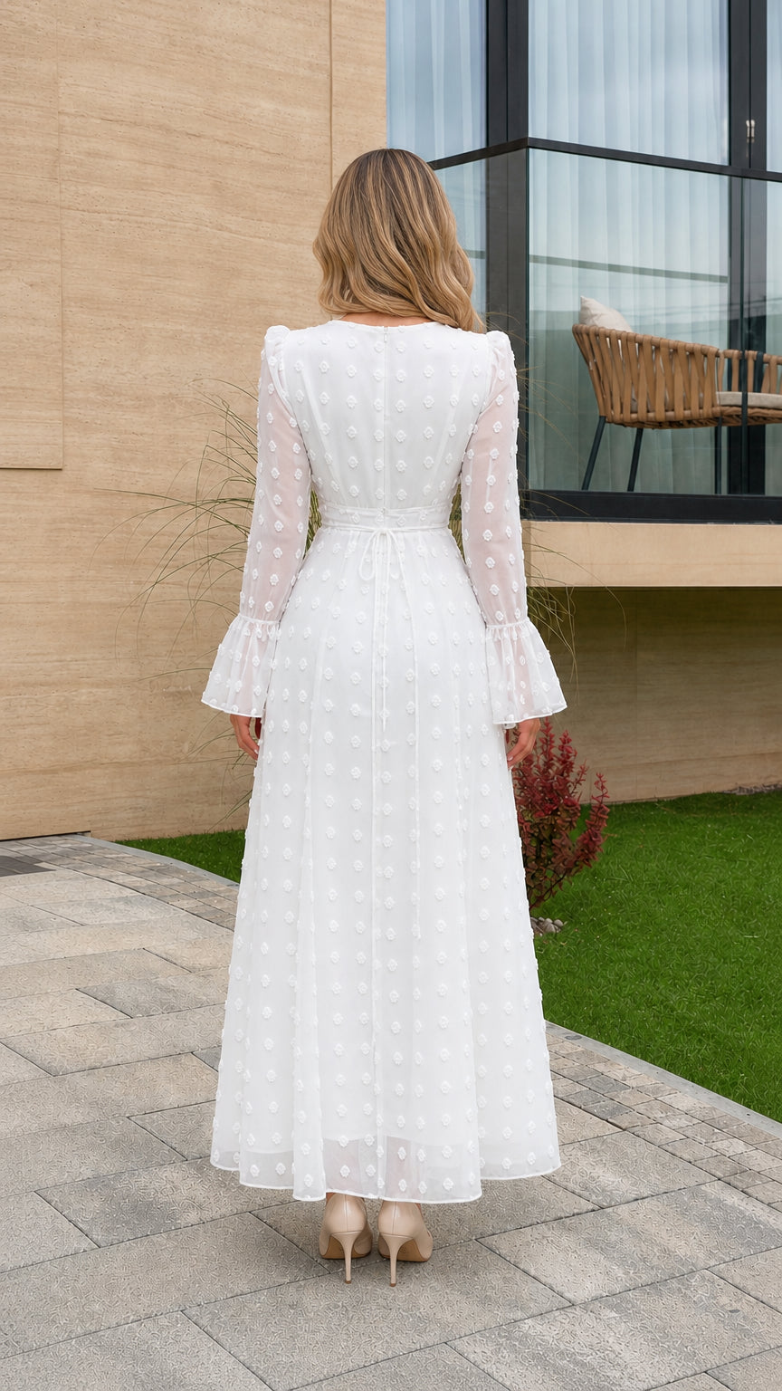 Back view of model showing A-line silhouette of white Swiss dot dress