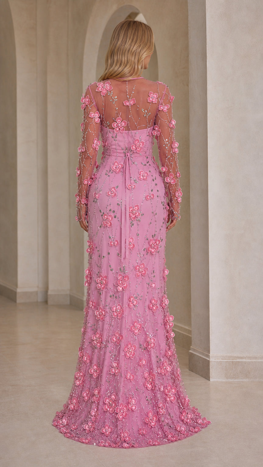Back view of model wearing pink embellished long sleeve formal gown