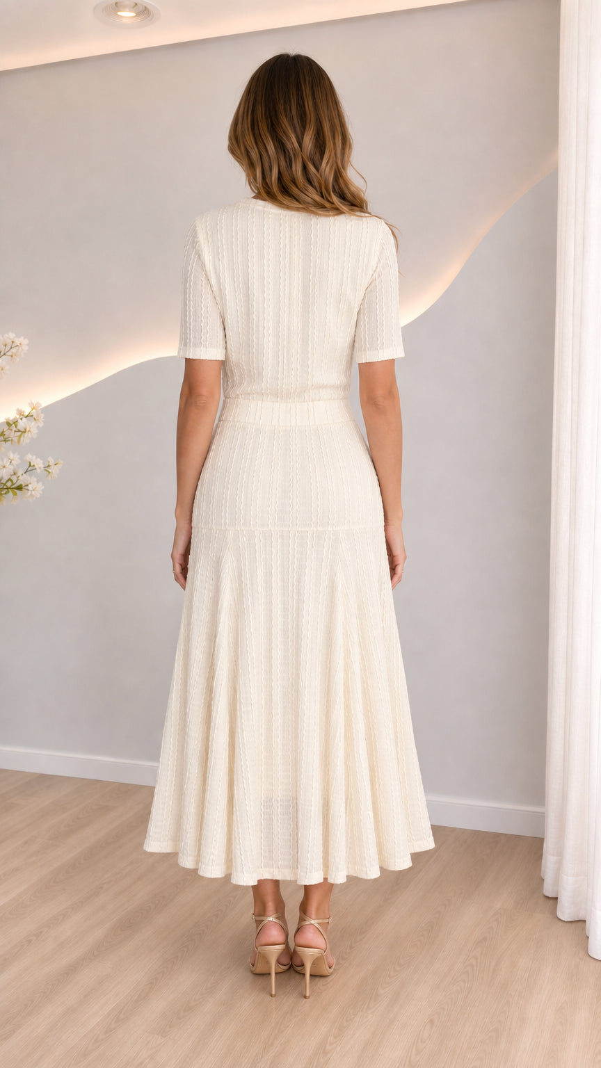 Back view of cream short-sleeve knit top and flared midi skirt ensemble