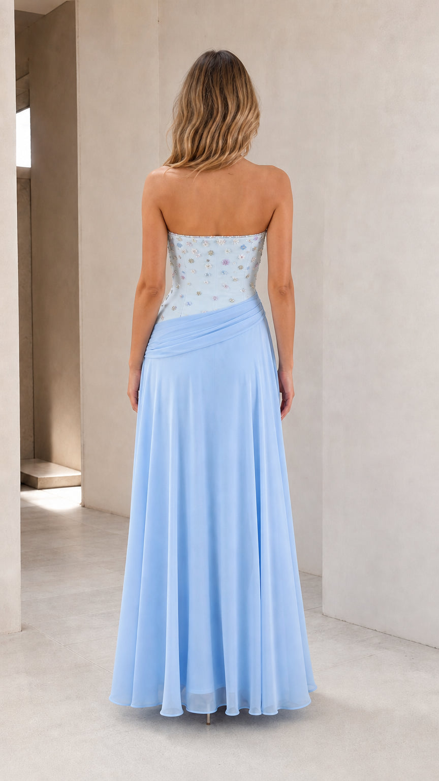 Back view of model wearing sky blue strapless chiffon evening gown