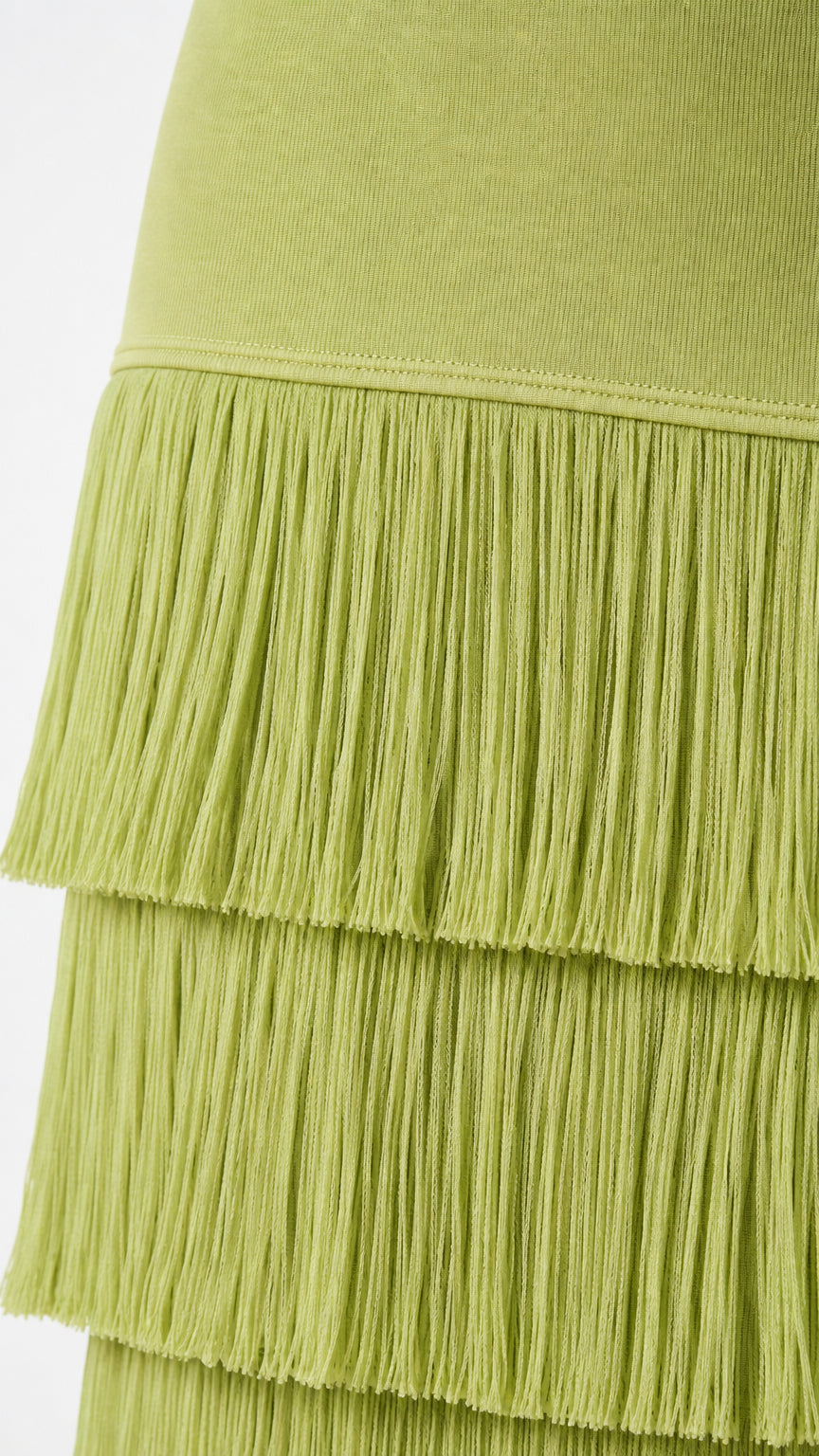 Close-up detail of pistachio green ribbed knit fabric and layered fringe hem construction