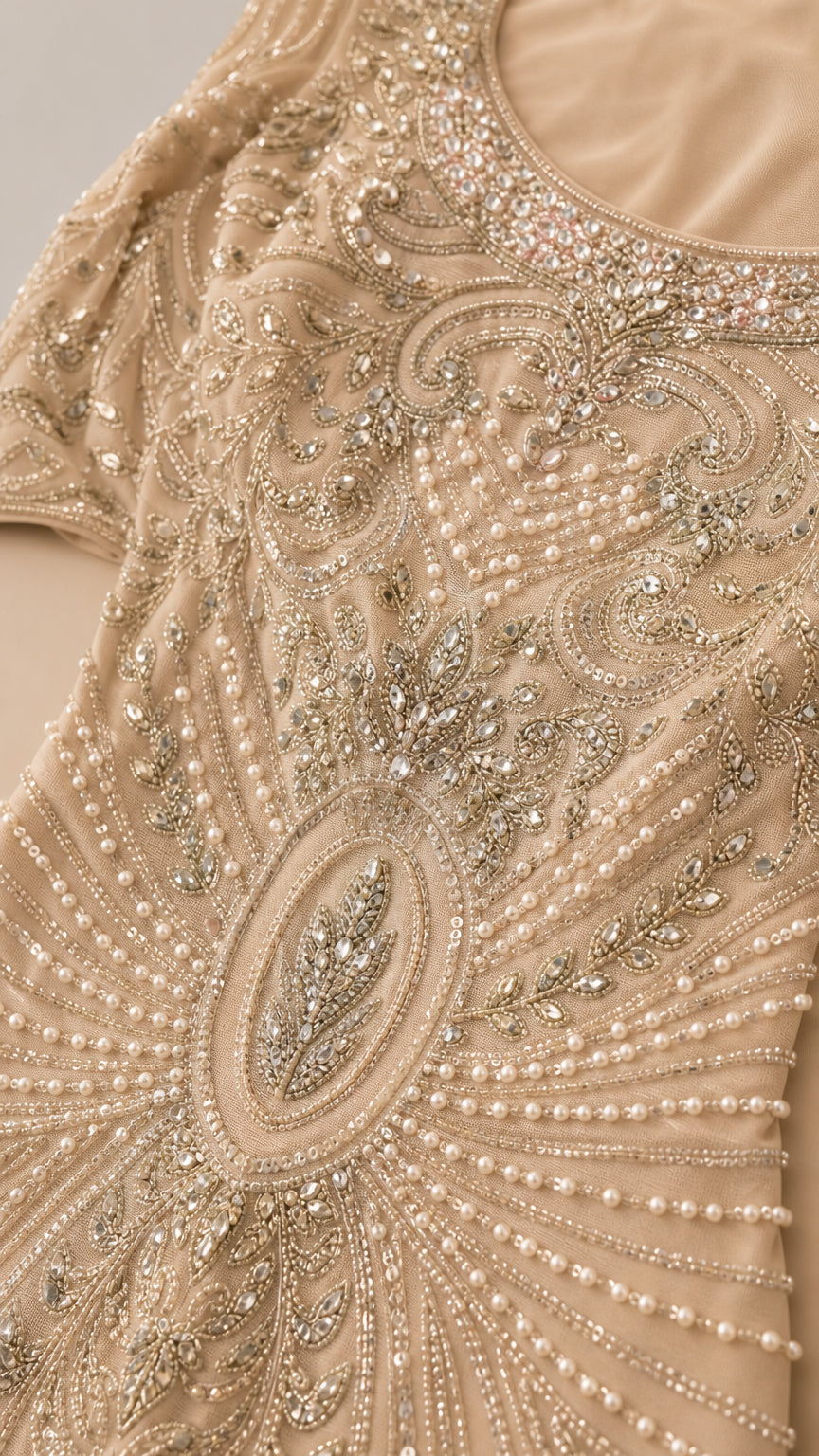 Close-up detail of intricate beadwork, pearls, and embroidery on Champagne dress