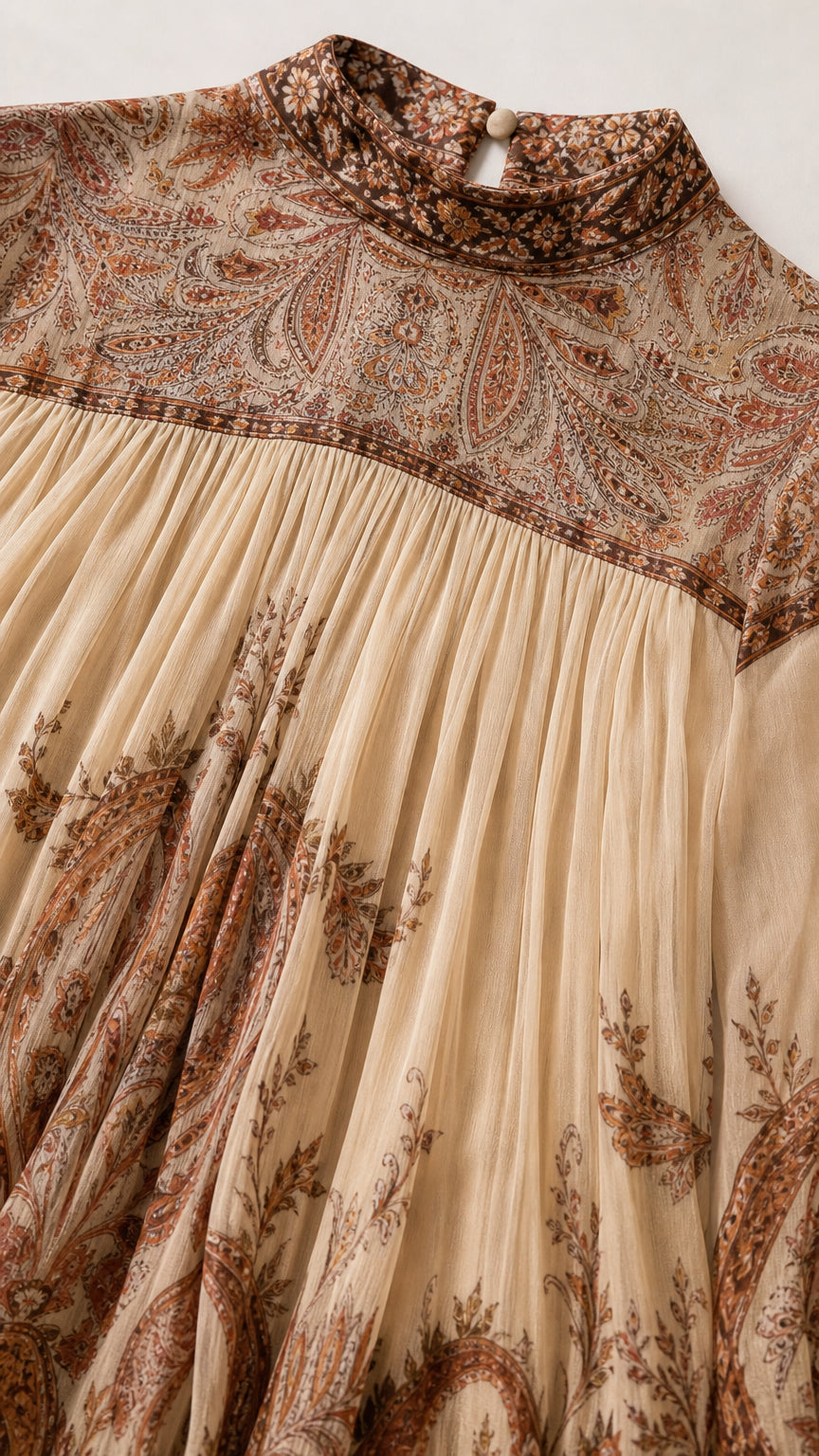 Close-up detail of high neckline, vintage paisley yoke, and micro-pleated fabric