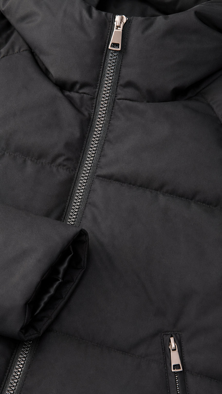 Close-up detail of smooth metallic front zipper, quilted fabric, and zippered pocket