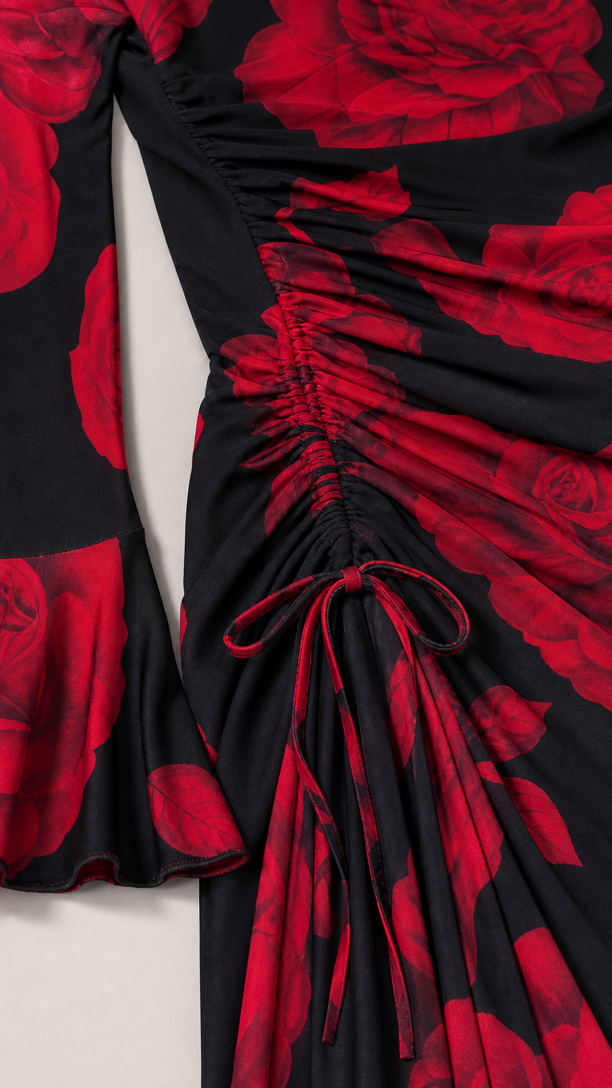 Close-up detail of side ruching and bell sleeve on black floral dress
