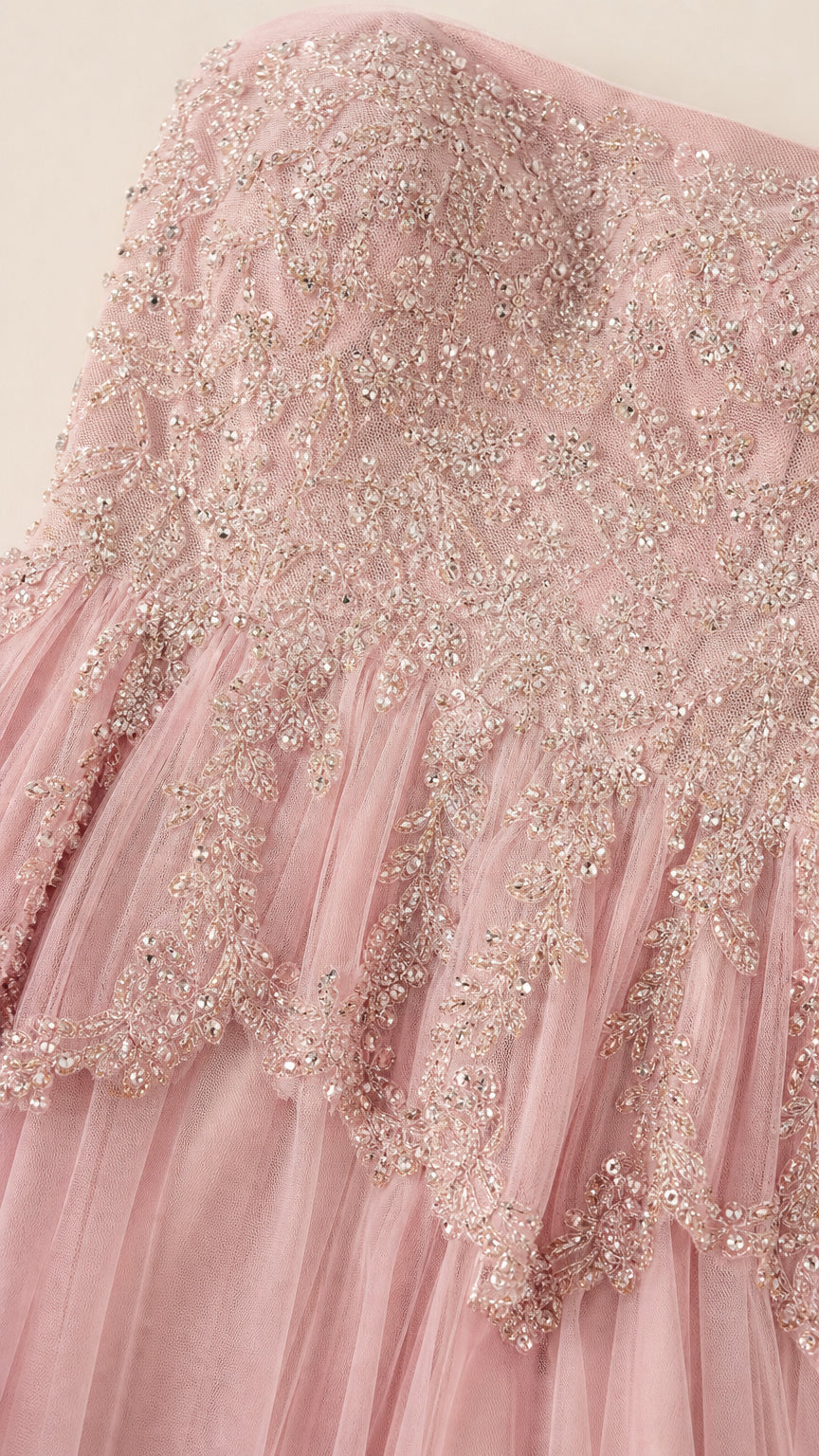 Close-up detail of shimmering beadwork, sequins, and scalloped peplum lace on dusty pink bodice