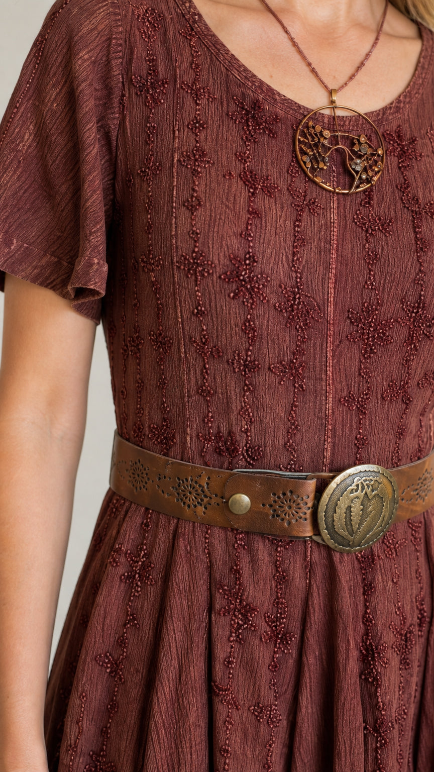 Close-up detail of rust embroidered fabric texture and scoop neckline