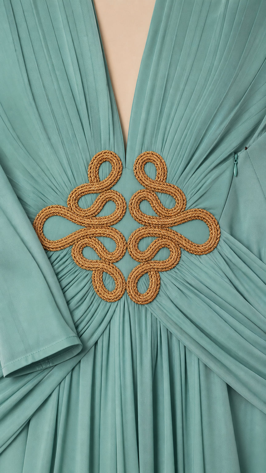 Close up of gold cord braided waist motif and pleated bodice