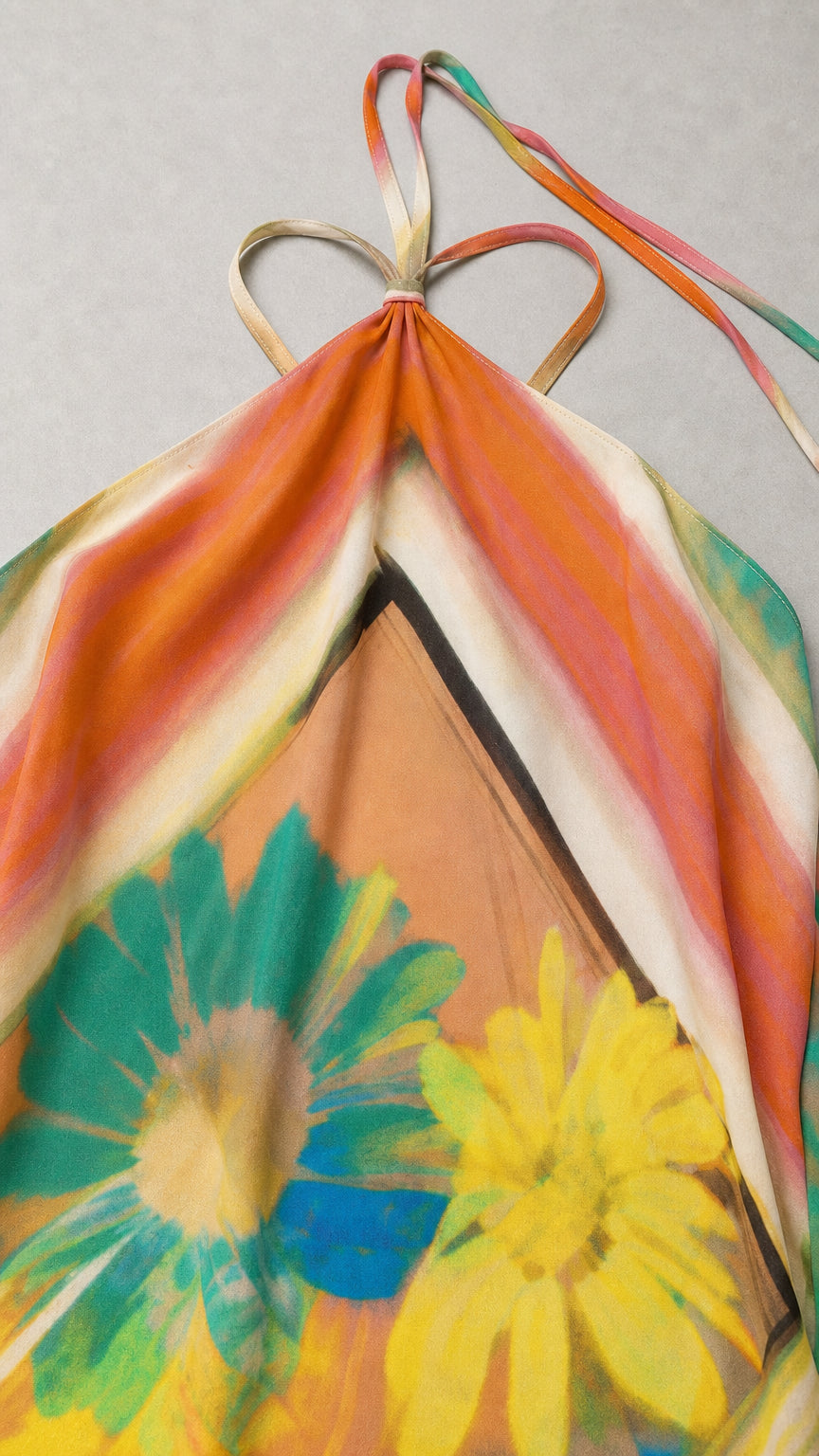 Close-up detail of halter neckline tie straps and vibrant graphic floral print