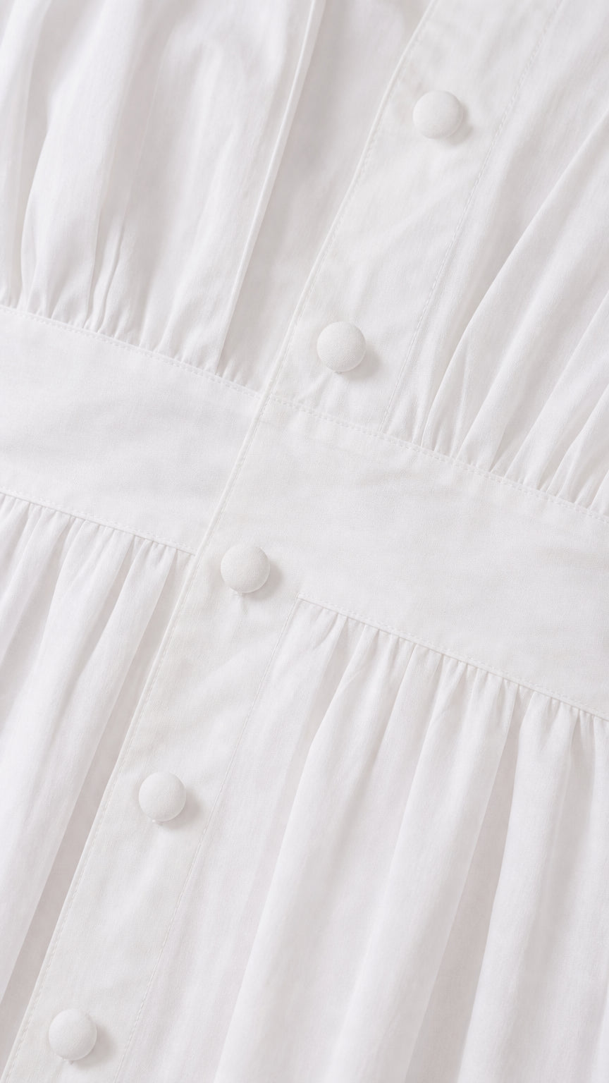 Close up view of covered button placket and pleated fabric details