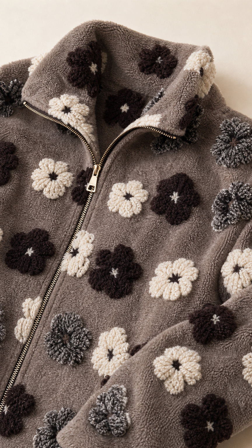 Close-up detail of zipper, collar, and 3D textured floral pattern on sherpa fleece fabric