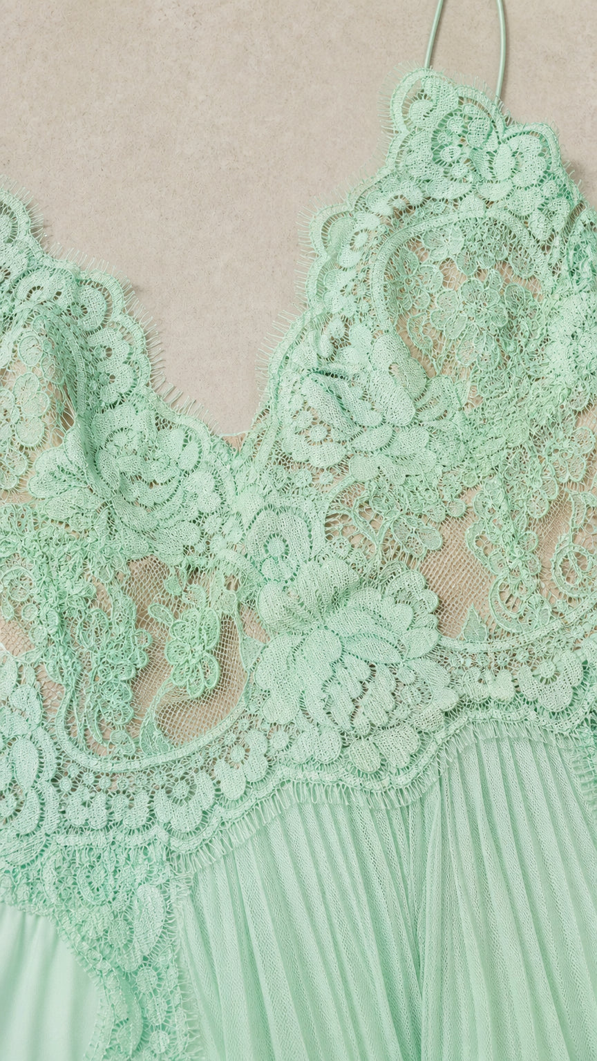 Close-up detail of mint green floral lace bodice with eyelash neckline