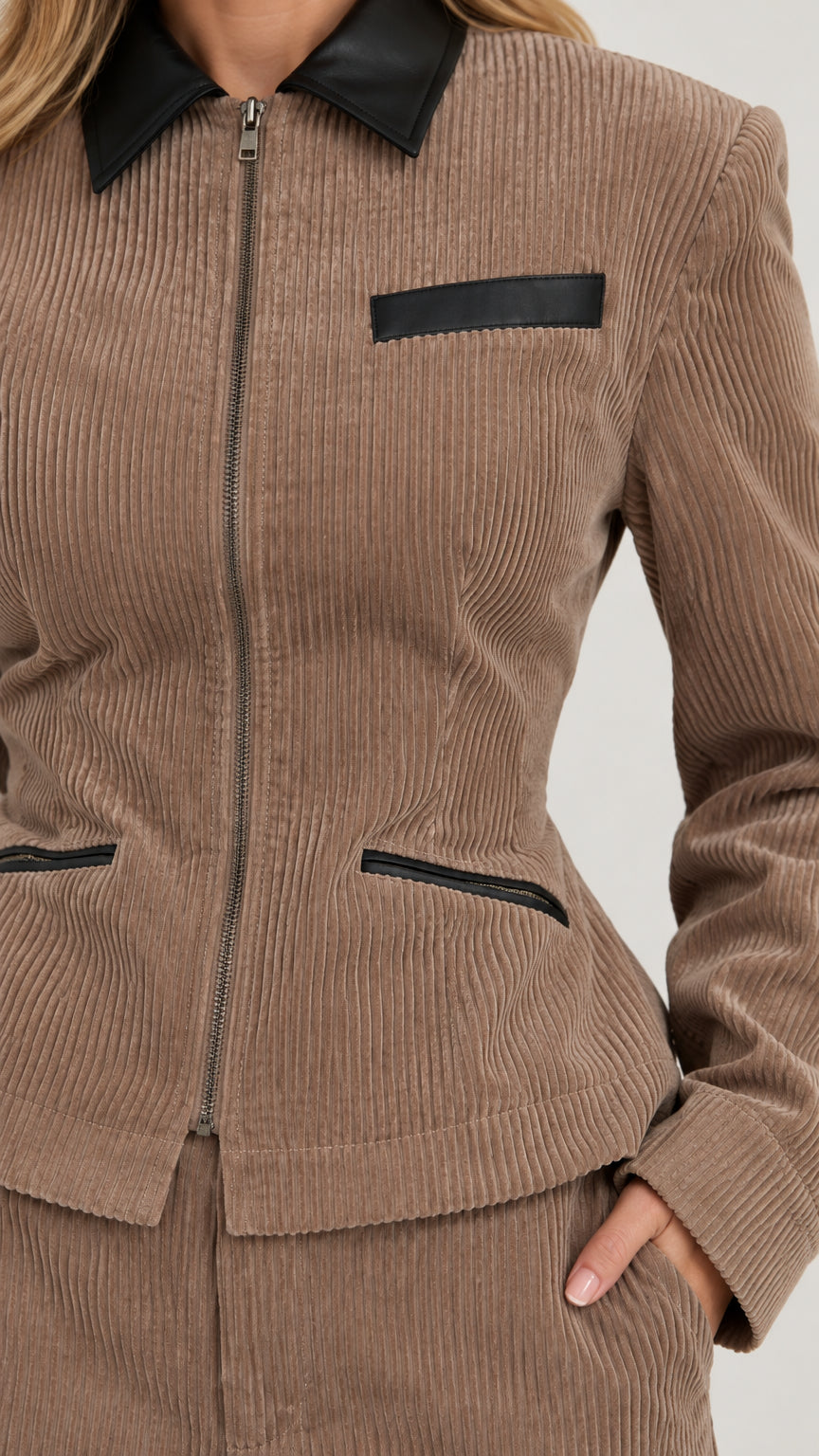 Close-up detail of taupe ribbed corduroy texture, zip closure, and contrast black collar