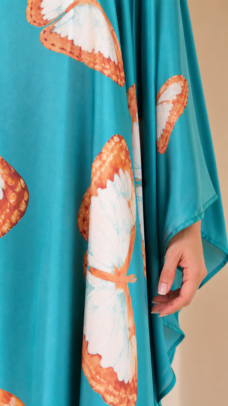 Close-up detail of Turquoise silky satin fabric and butterfly wing graphic print