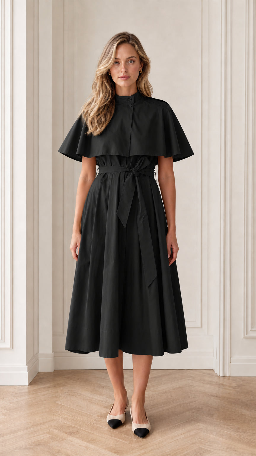 Model wearing black trench capelet belted midi dress