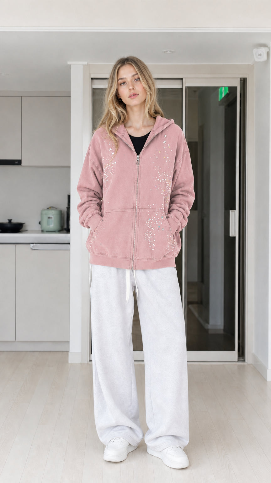 Front view of woman wearing dusty pink rhinestone star zip-up hoodie