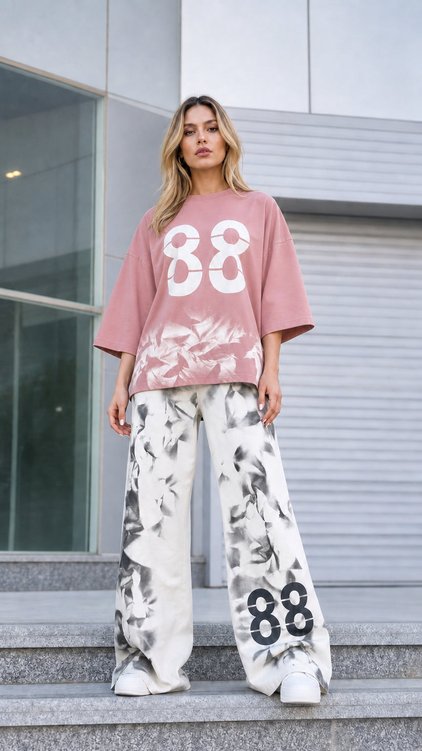 Front view of woman wearing dusty pink oversized graphic tee and matching wide-leg pants
