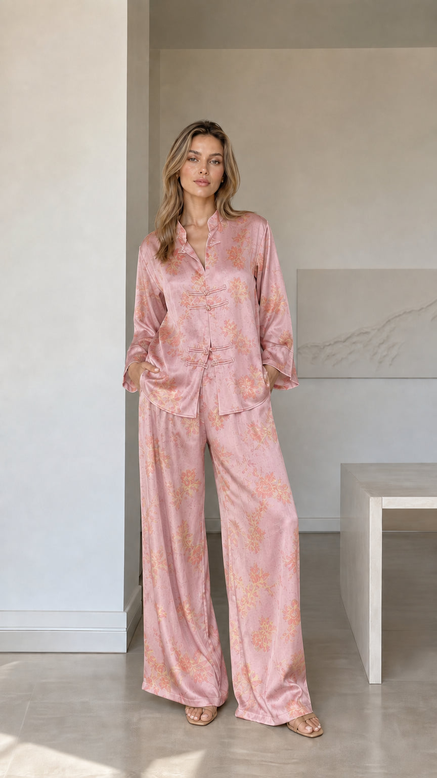 Model wearing dusty pink floral satin pajama set with frog button top