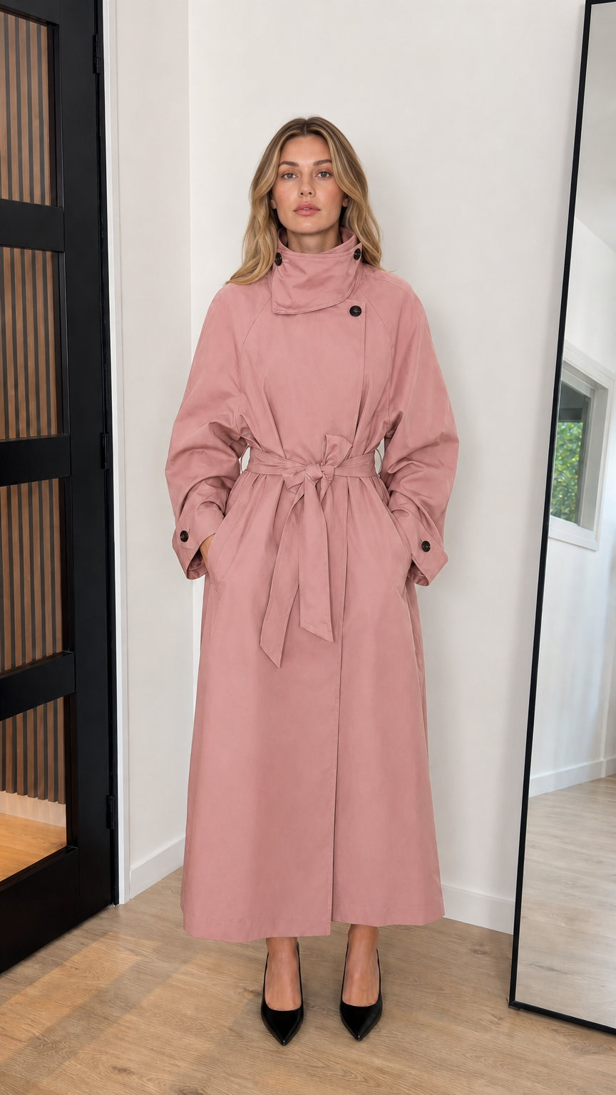 Front view of model wearing a dusty pink high neck belted longline trench coat