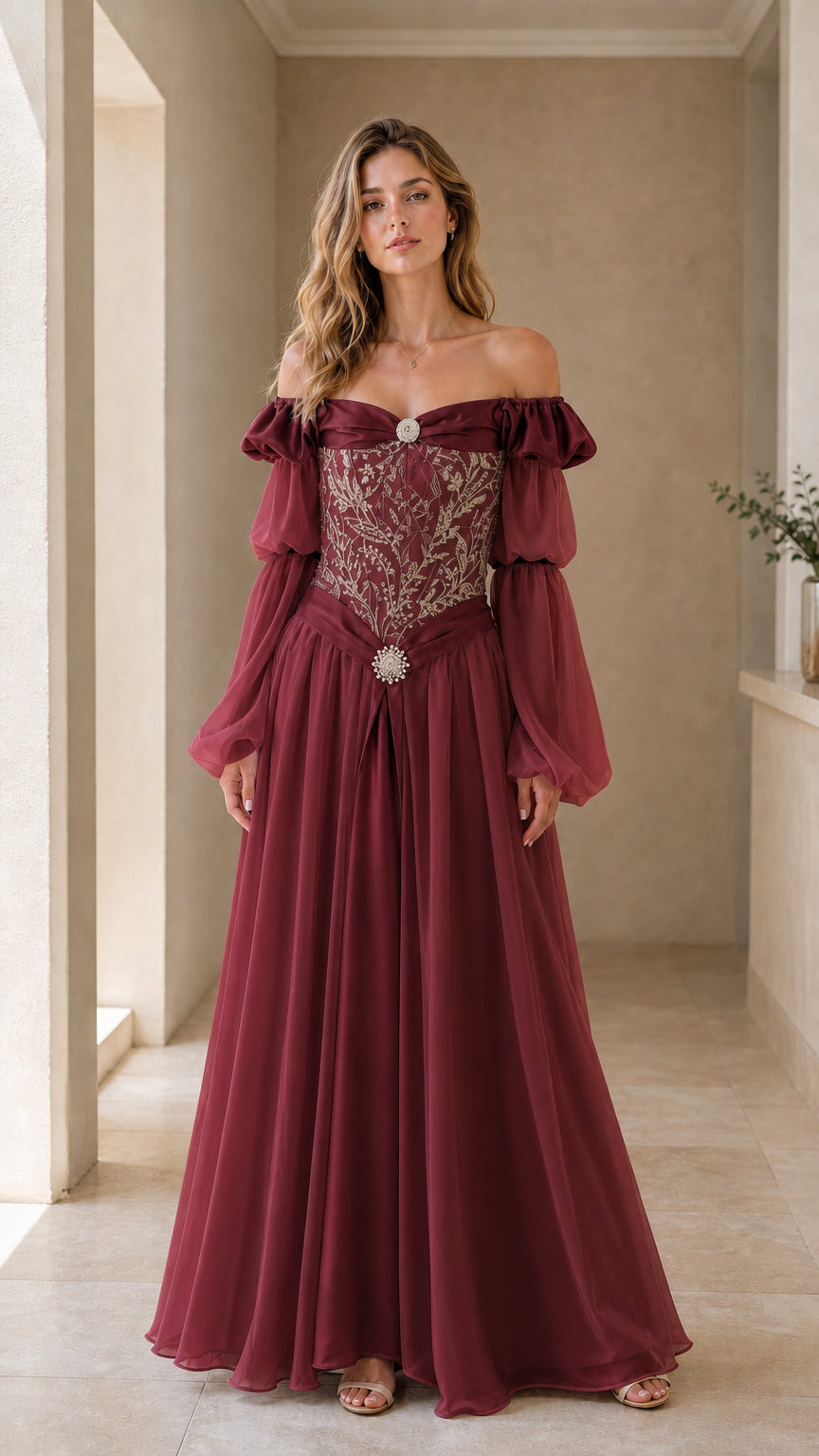 Model wearing burgundy wine red Renaissance gown with ornate embroidery and brooch accents