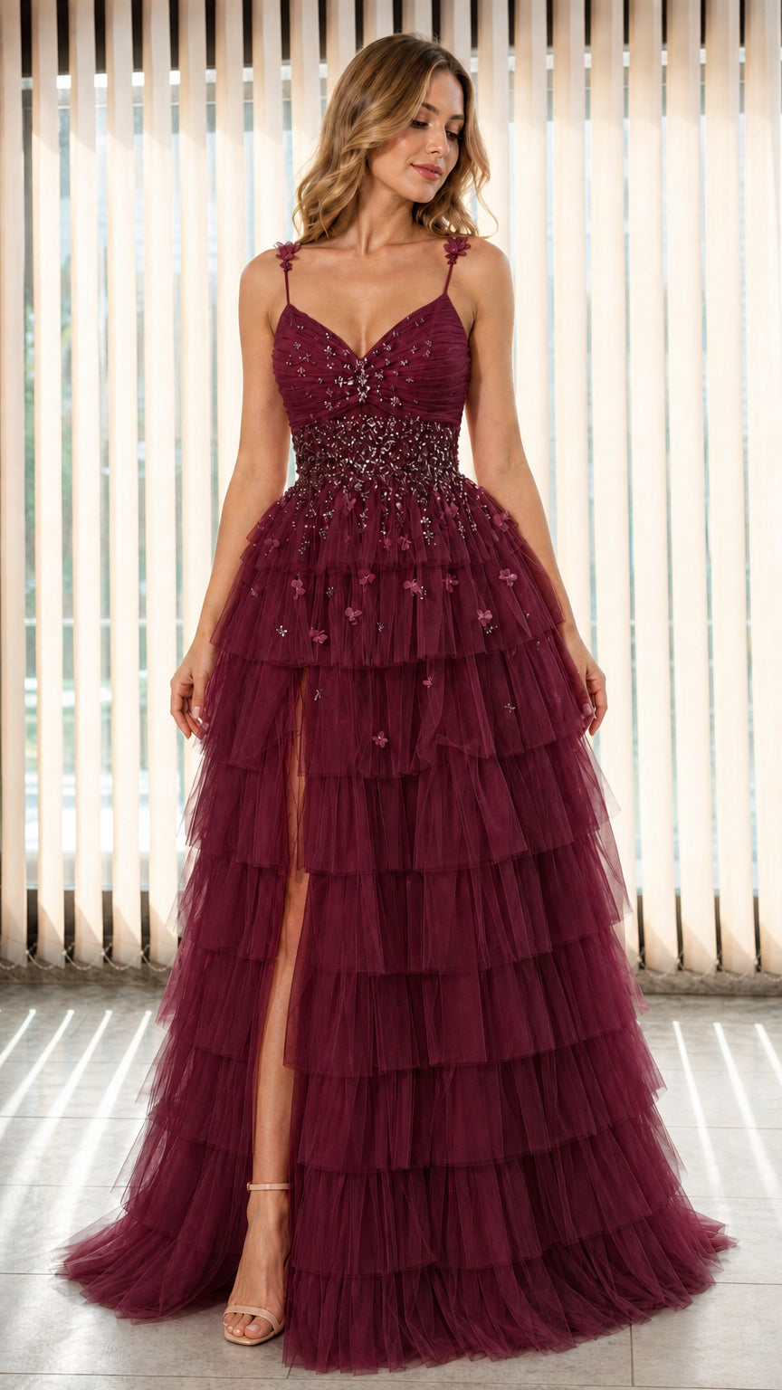 Model wearing Burgundy red tiered tulle formal dress with leg slit